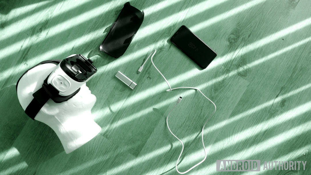 Gear VR head and phone Top view of a Samsung gear virtual reality kit with Galaxy S8 laid on a wooden floor.