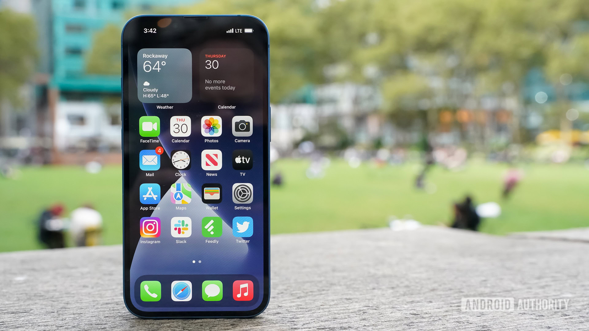 Apple iPhone 13 display left centered park Apple iPhone 13 display left centered taken outdoors in a park.