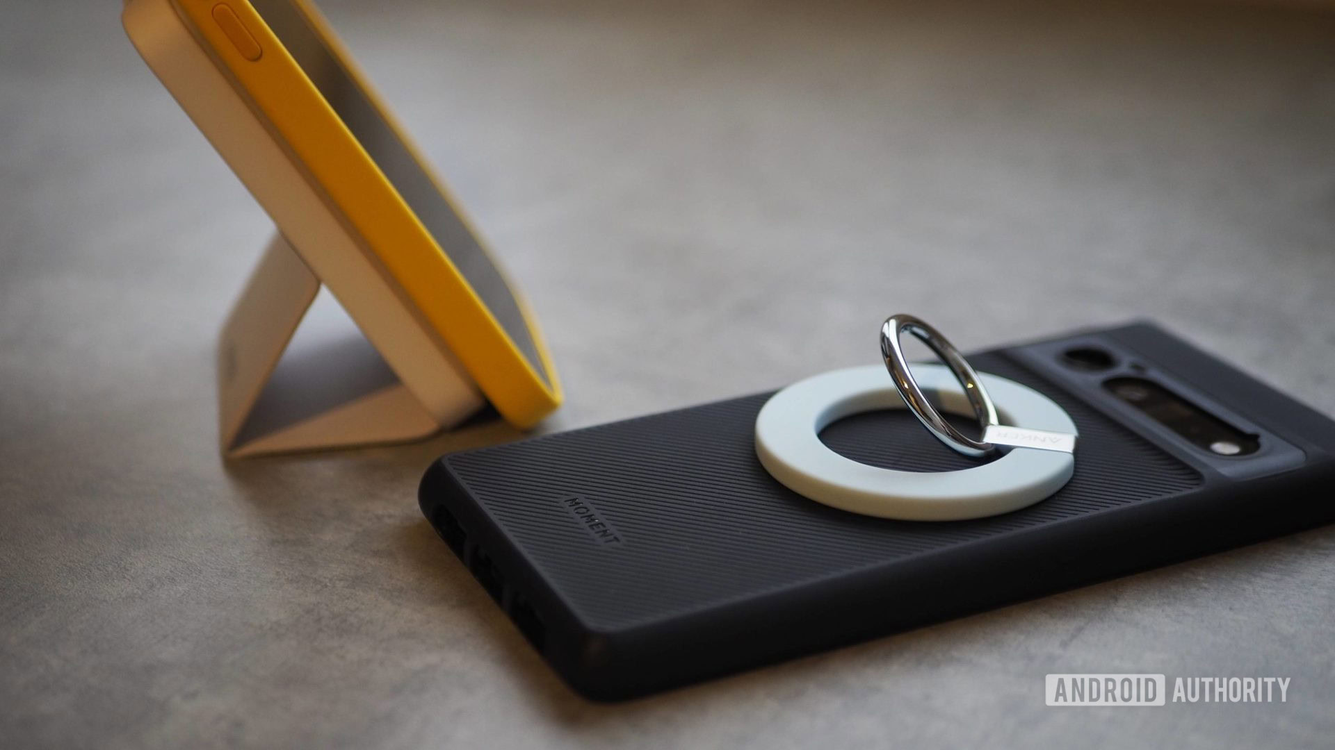 magsafe anker grip power bank Anker MagGo 610 phone grip on Pixel 6 Pro with Moment (M) Force case, MagGo 622 power bank propping up iPhone 12 Pro Max with yellow MagSafe case