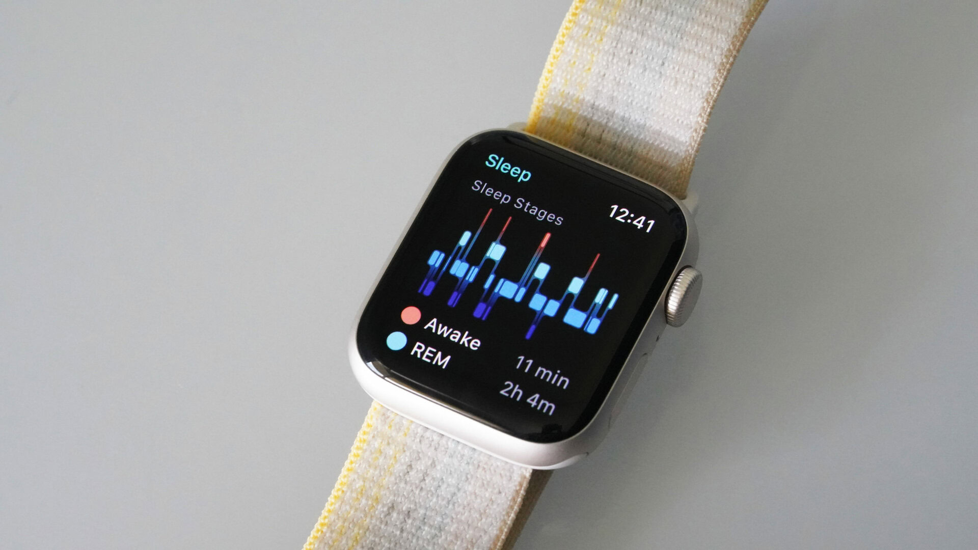 Apple Watch SE 2 Sleep Stages An Apple Watch SE 2 rests on a white surface displaying a user's sleep stages.