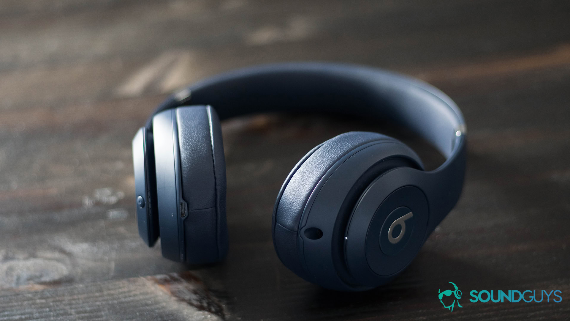 Beats Studio 3 Wireless headphones full The Beats Studio 3 Wireless headphones in navy on a dark wooden surface.