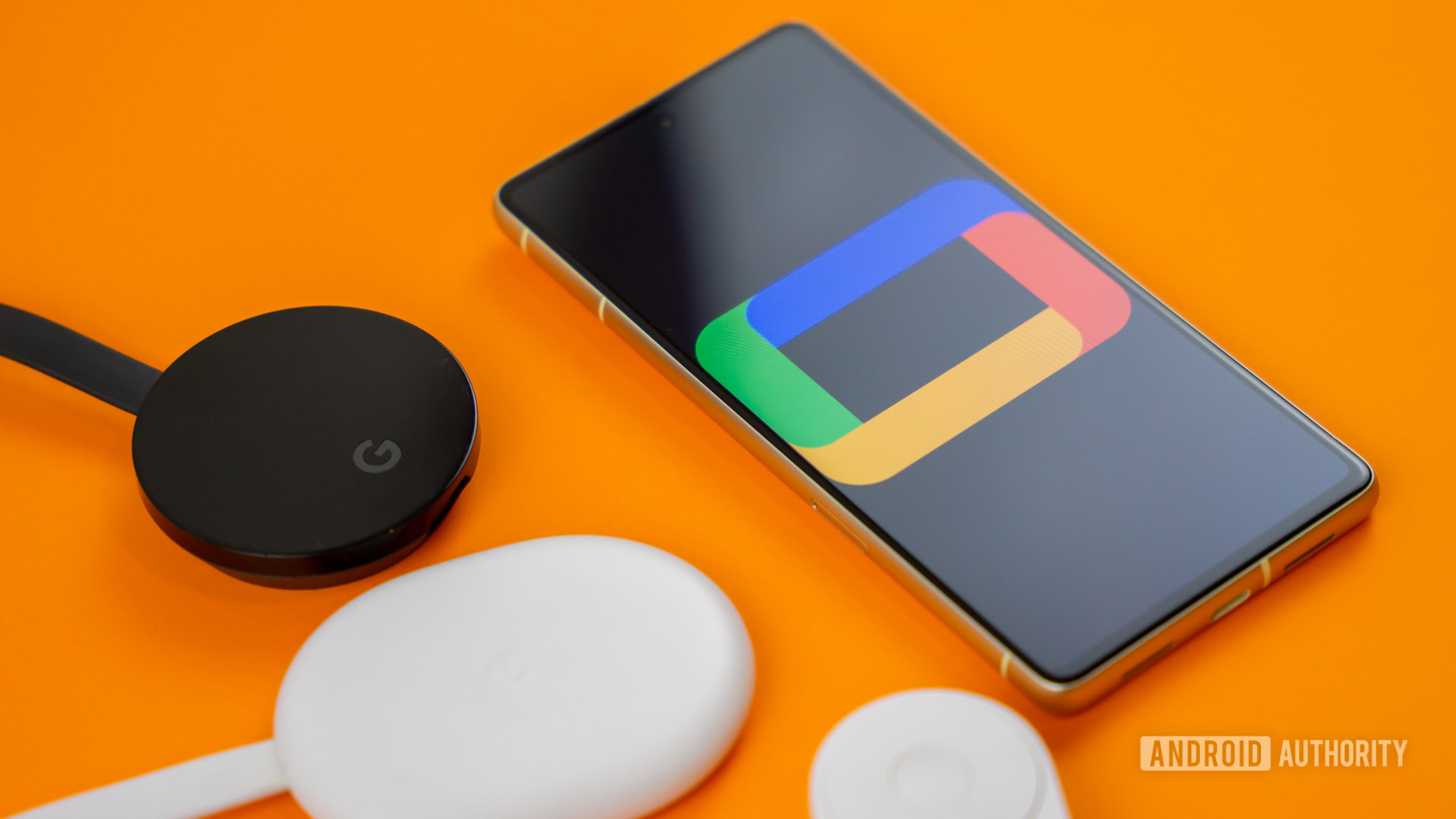 Google TV logo on smartphone next to Chromecast devices and remote Stock photo 4 Google TV logo on smartphone next to Chromecast devices and remote Stock photo 4