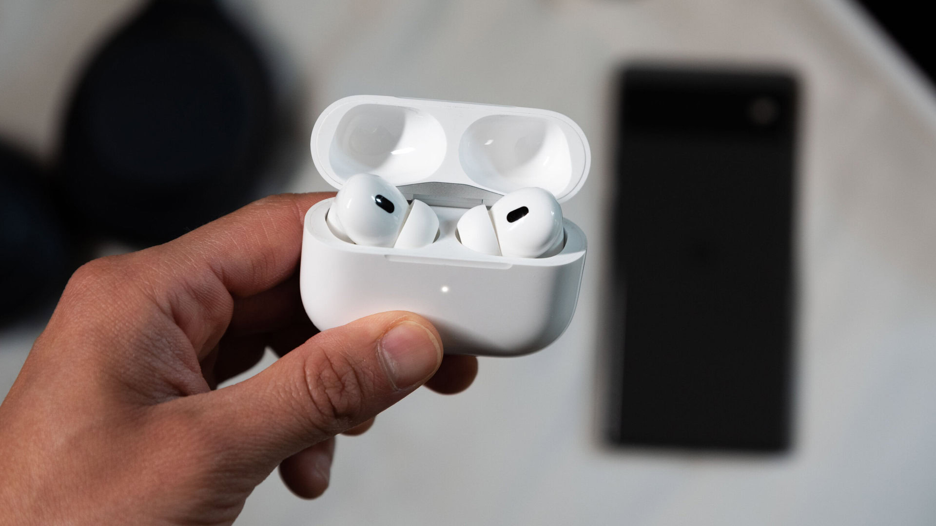 AirPods Pro 2nd generation Google Pixel 6 phone pairing 2 A hand holds the AirPods Pro 2nd generation while in pairing mode in front of a Pixel 6 phone.